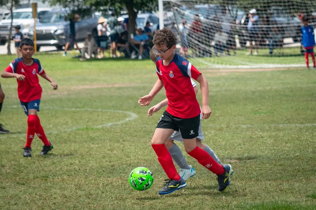 Player dribbling past defender on grass
