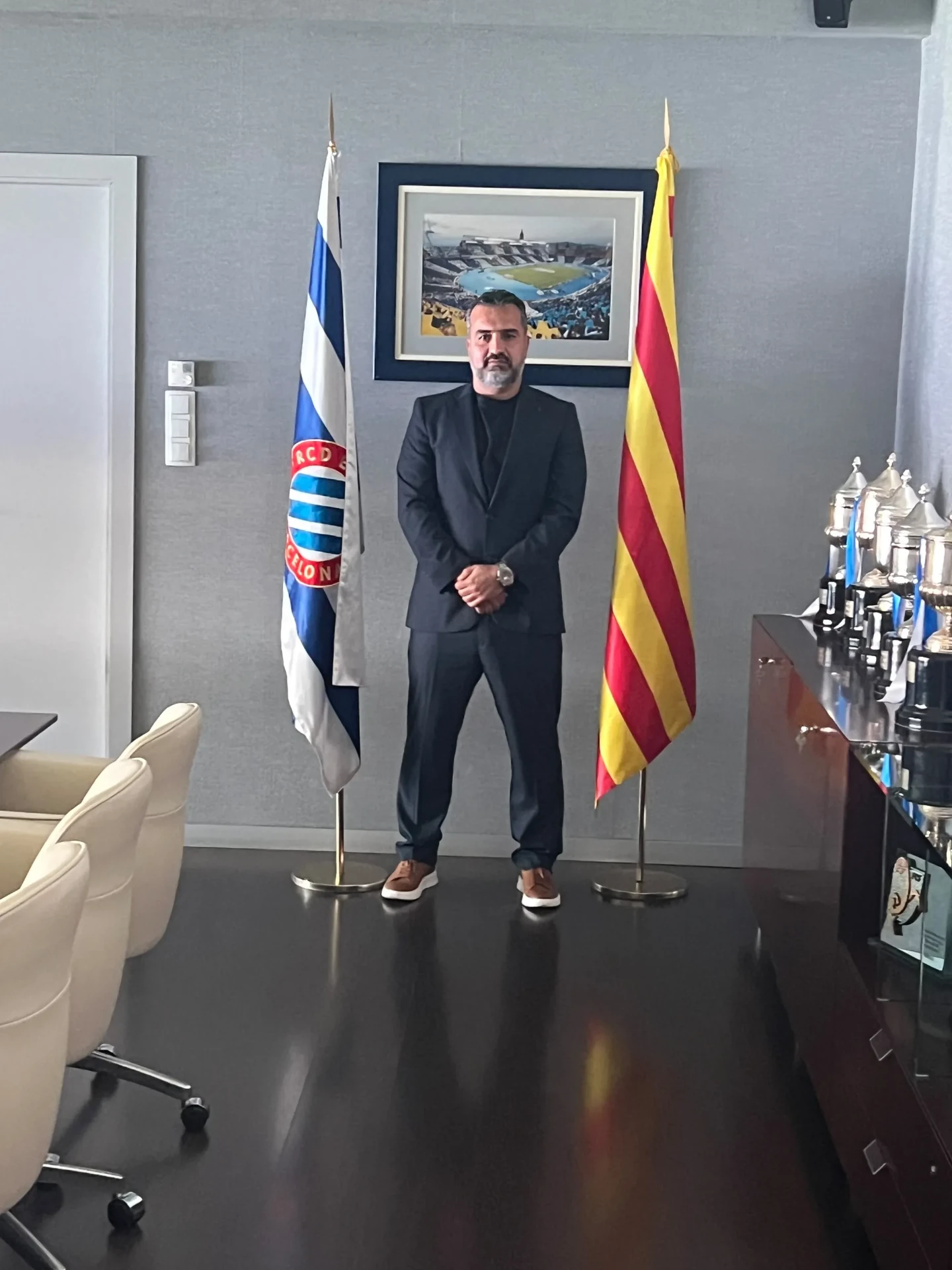 RCDE Academy Texas director standing between the RCD Espanyol and Catalan flags inside the club president's office in Barcelona