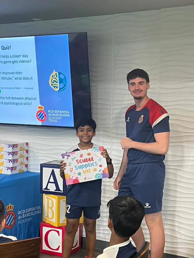 Player receiving school supplies kit after winning the quiz