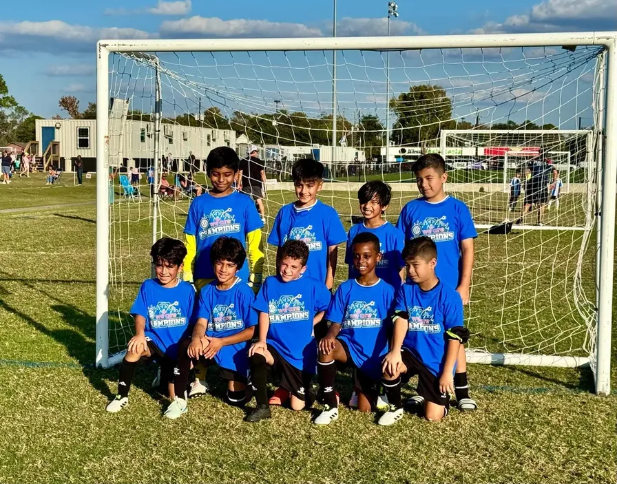 Champions team in front of the goal with trophy shirts