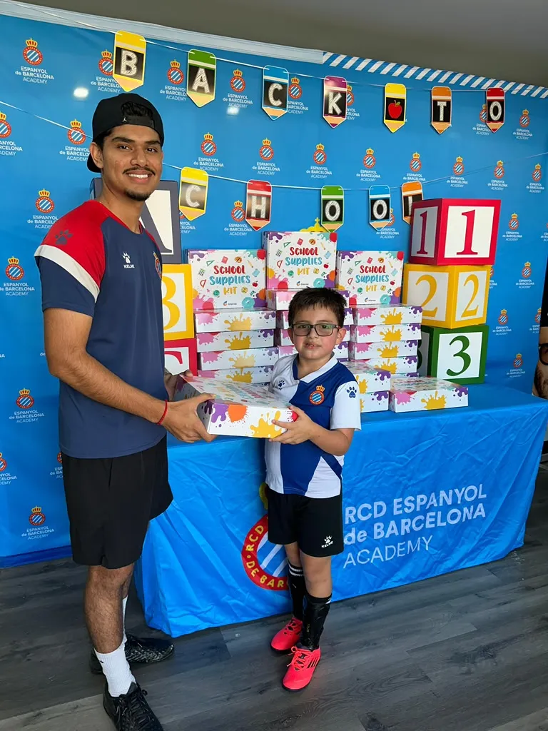 Coach handing back-to-school supplies kit to player